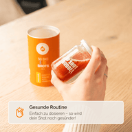 VITAMINTROPFEN D3K2 KIDS: Pipette über einem orangefarbenen Shotglas